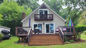 Une maison à deux étages avec un balcon, une terrasse et une porte d’entrée.