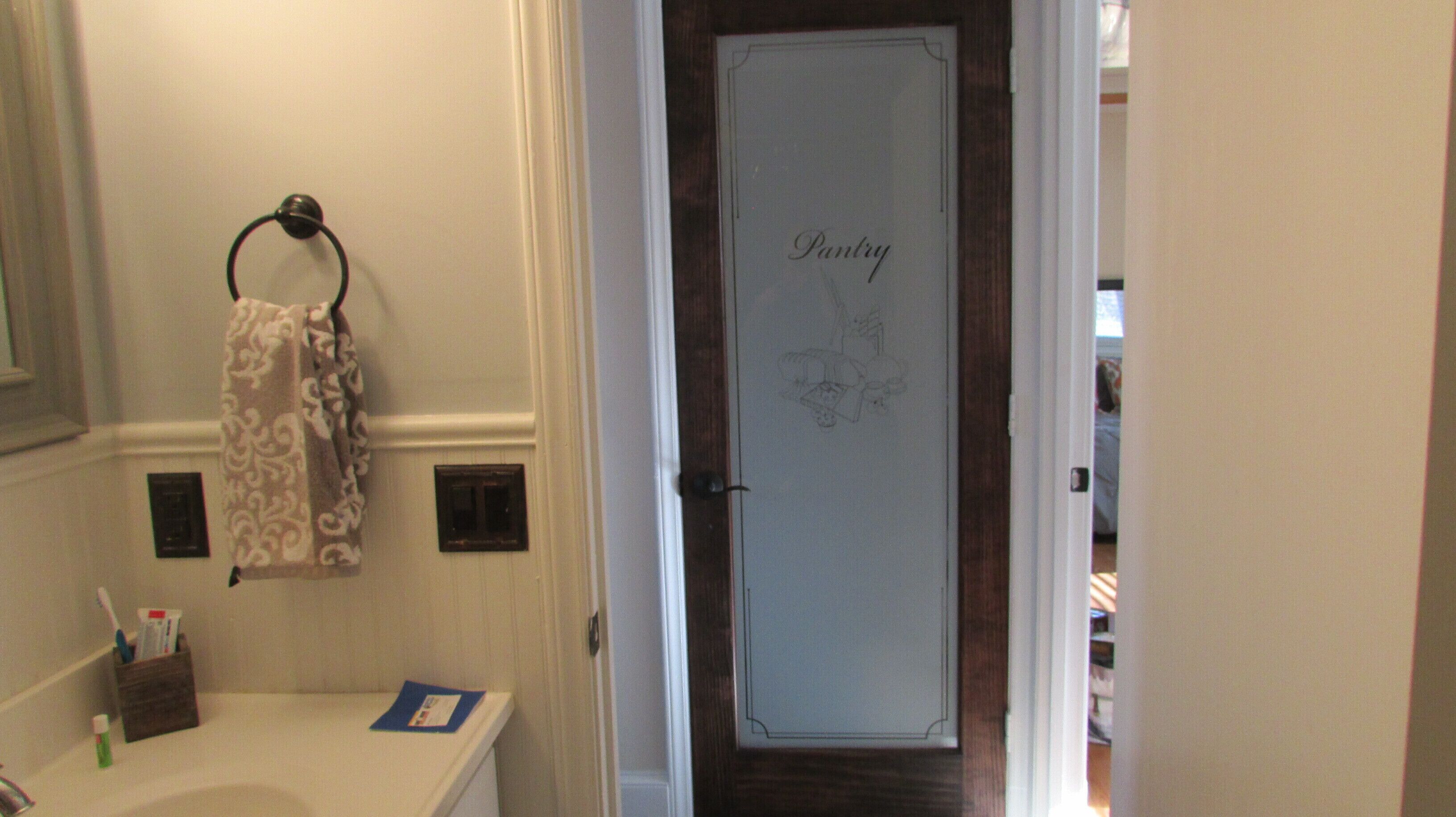 A bathroom with a towel rack, toothbrush holder, and a door with a 'Pantry' sign.
