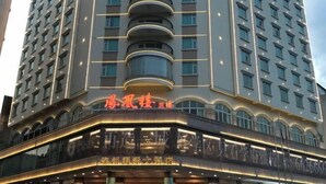 Ein mehrstöckiges Hotel mit modernem Design, mit Balkonen und auffälliger Beschilderung.