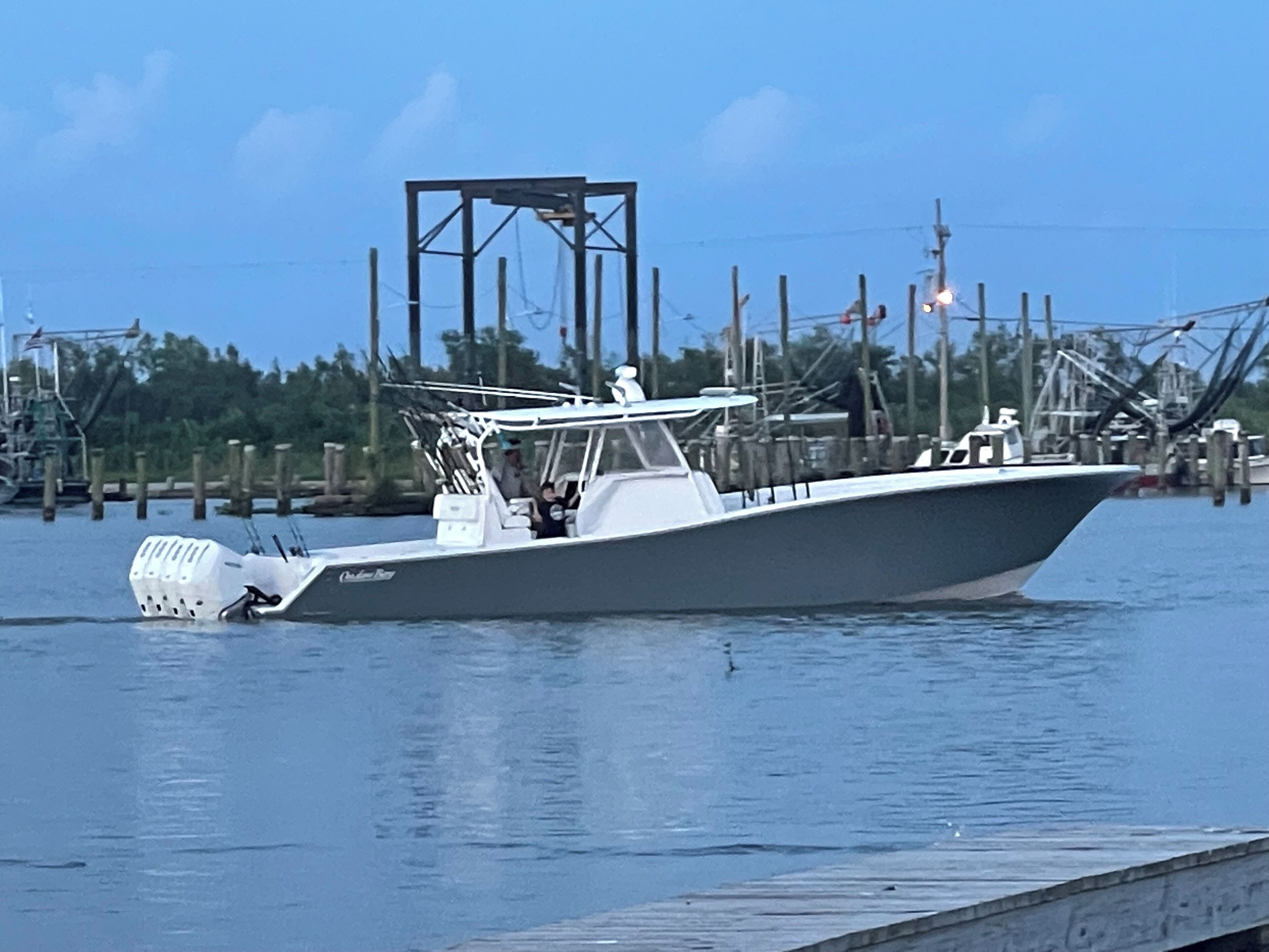 A boat docked at a pier with a clear view of the water and distant shoreline.