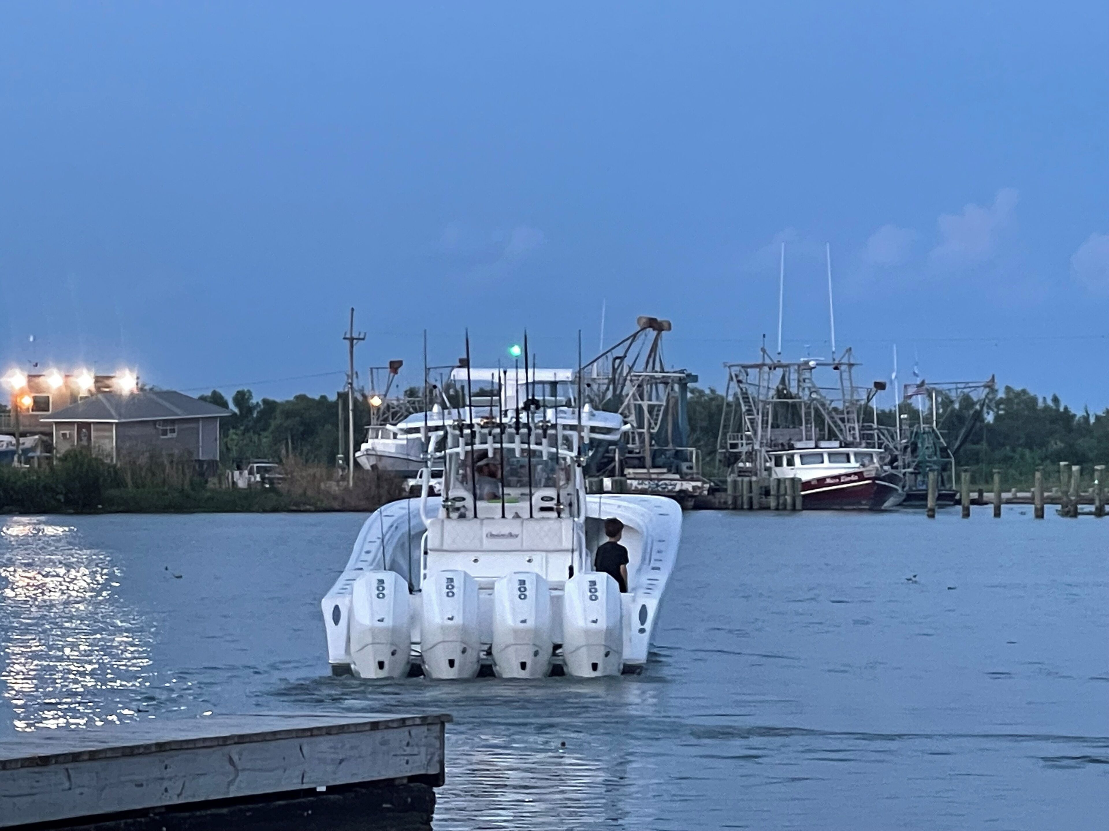 A boat docked at a marina with multiple boats and a dock in the background.