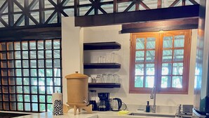 A kitchen with a large window, a coffee maker, a kettle, and a sink. - Beachfront  3-Bedroom Home in Santa Teresa with AC  (Santa Teresa, Mal Pais)
