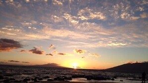 A beach at sunset with a silhouette of a mountain in the background. - SEPTEMBER VALUE Last minute cancelation! A/C, Ocean Views Near Keawakapu Beach! (Kihei)