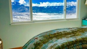 Une chambre avec une grande fenêtre donnant sur l’océan.