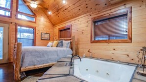 A log cabin bedroom with a bed, a bathtub, and wooden walls.