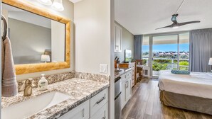 Une chambre d’hôtel avec salle de bain, coin repas et balcon offrant une vue.