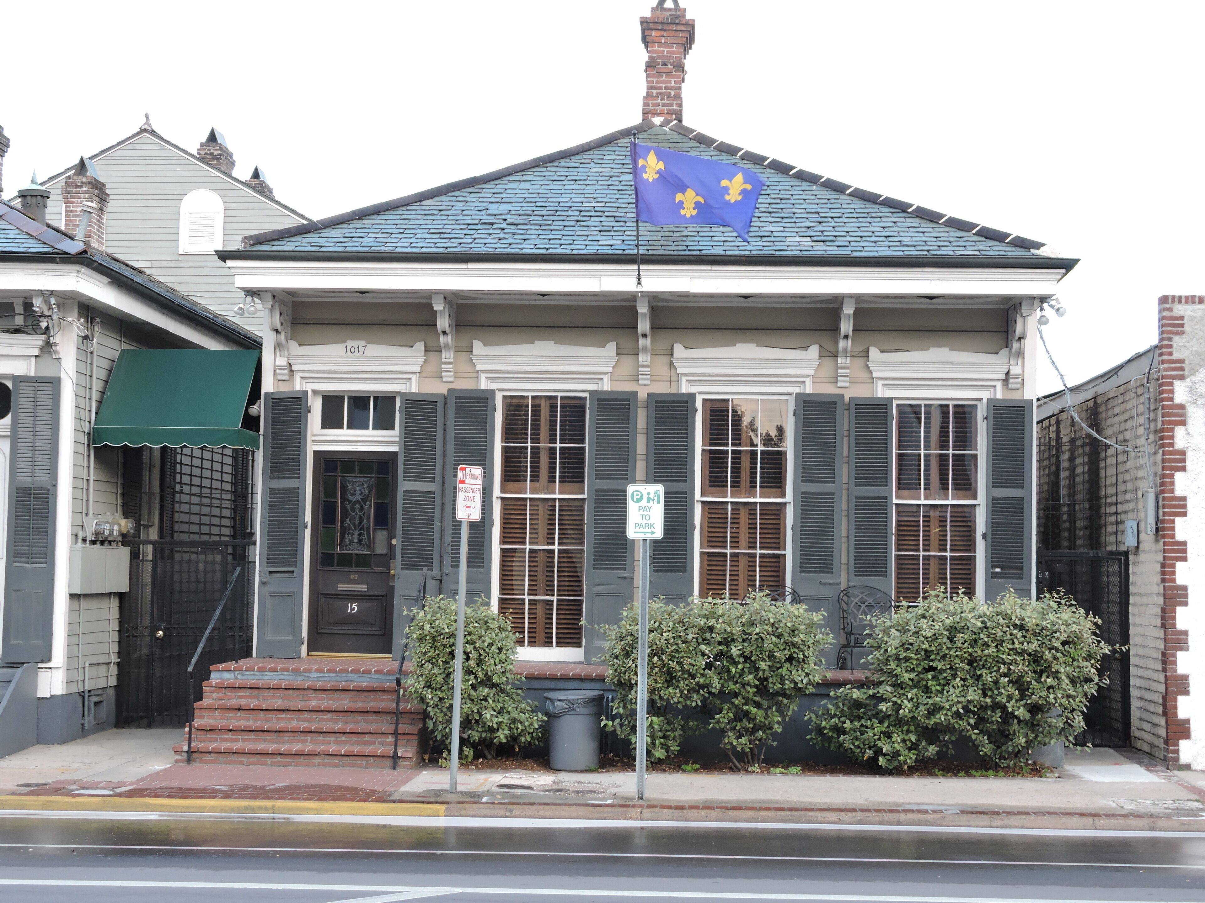 A building with a blue roof, a flag, and a 'No Parking' sign.