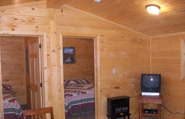 A wooden cabin with a bed, a television, and a small table. - American Pines Cabin, 5 Miles from Mt. Rushmore! (Keystone)