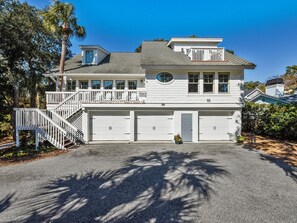 A two-story house with a balcony, a garage, and a driveway.