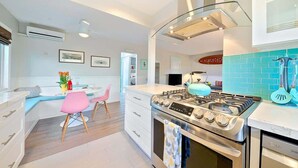 Una cocina moderna con estufa a gas, horno y un amplio ventanal.