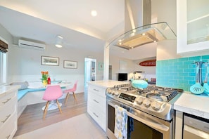 A modern kitchen with a gas stove, oven, and a large window.