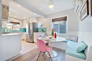 Enjoy meals at the central island with a sink and stove, surrounded by cabinetry and a backsplash.