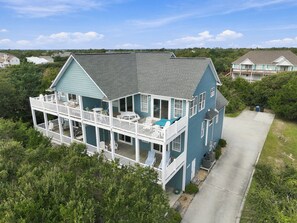 A two-story house with a balcony, a garage, and a driveway.
