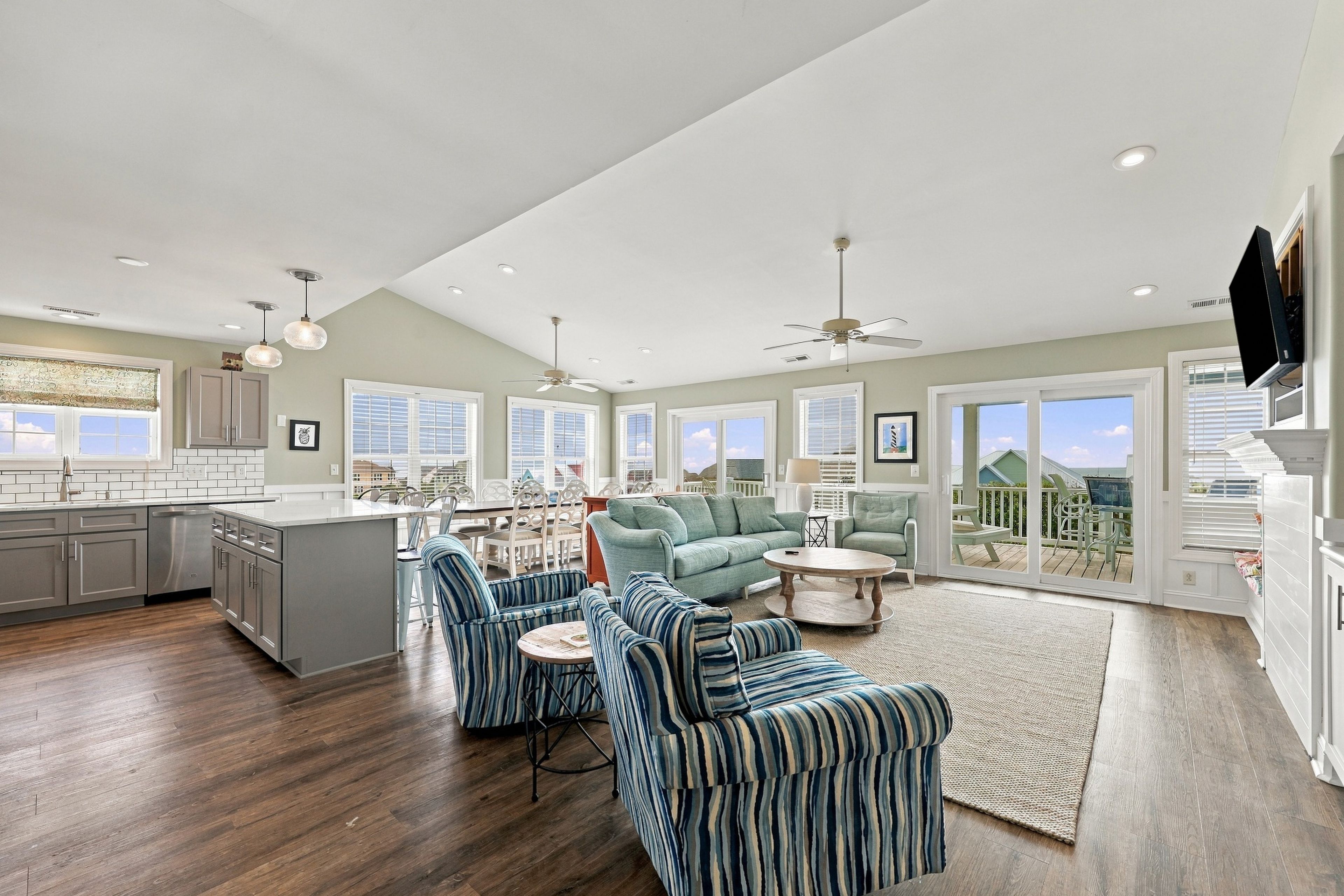 A spacious living area with a kitchen, dining space, and a balcony with a view.