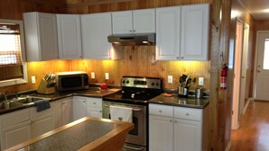 A kitchen with white cabinets, a stainless steel microwave, a stove, and a sink. - HONEYHOLE 3BR.  Beautiful, spacious, and best of all...NO BUNK BEDS! (Venice)