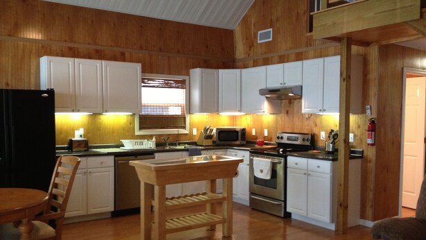A kitchen with wooden cabinets, a central island, a dining table, and a ceiling fan. - HONEYHOLE 3BR.  Beautiful, spacious, and best of all...NO BUNK BEDS! (Venice)