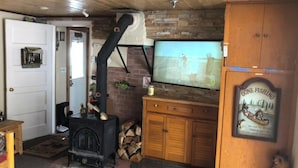 A cozy room with a fireplace, wooden cabinets, and a television.
