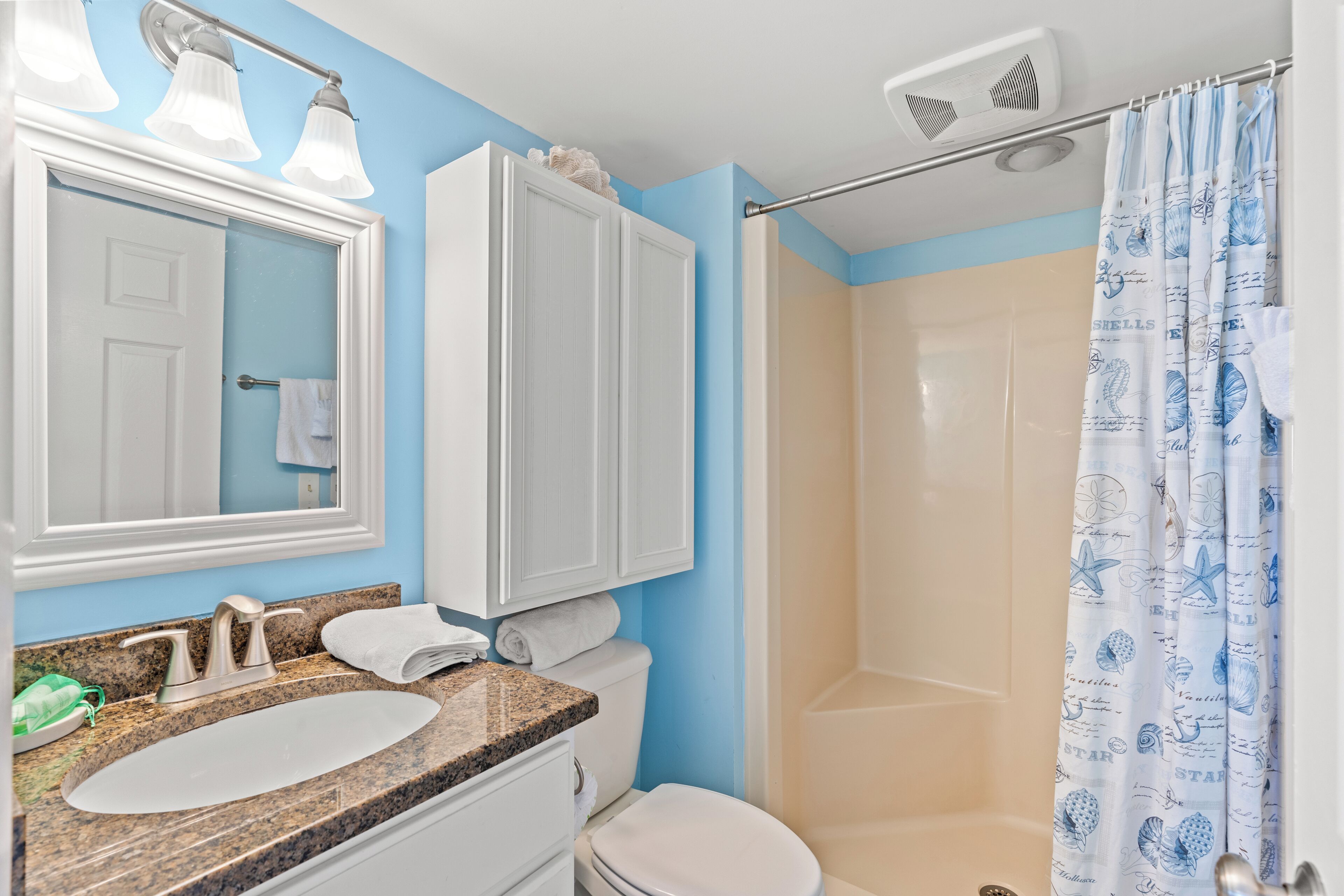 A bathroom with a sink, toilet, and shower.