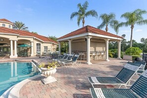 A pool area with lounge chairs, a covered seating area, and a pool. - Water Front Villa in Emerald Island, 3 Mi to Disney, 4BdRm/3Ba,Theme Rm,Pool (Kissimmee)