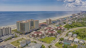 A coastal cityscape with a beachfront, high-rise buildings, and a mix of residential and commercial structures. - 10% off  3-7 nights thru Oct. Cherry Grove. 3BR 3BA OF condo. Sleeps 8. (North Myrtle Beach)