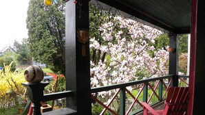 A wooden deck with red railings, a table, and chairs. - Beautiful Victorian Home - Central Vancouver! (Vancouver)