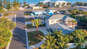 A residential area with houses, a road, and a view of the ocean. - TIKI BLUE SOUTH: Walk to Beach + Heated Pool (Satellite Beach)