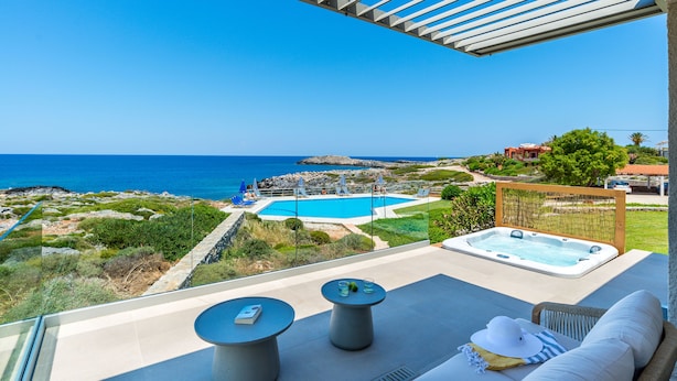 A balcony with a view of a pool and the sea, a hot tub, and outdoor seating. - Seafront Junior Villa with private heated Jacuzzi (Chania)