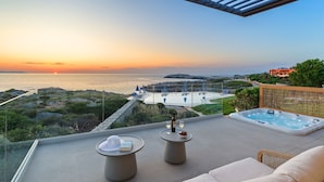 A rooftop terrace with a hot tub, two tables with drinks, and a view of the sea at sunset. - Seafront Junior Villa with private heated Jacuzzi (Chania)