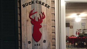 Un senyal de fusta amb un cap de cérvol i la inscripció 'Buck Creek Band'.
