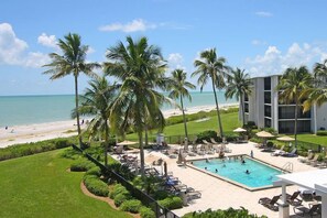 A resort with a swimming pool, palm trees, and a beach view. - Sundial B306--Direct Beachview, Newly Renovated, Steps to Beach (Sanibel Island)