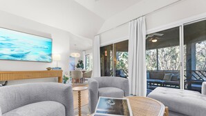 A modern living room with grey upholstered chairs, a wooden coffee table, and a large painting on the wall. - Villa Palma, newly renovated, central, in popular location (Johns Island)