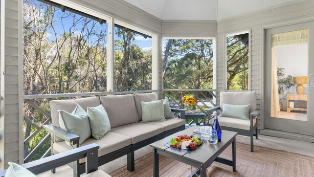 A sunroom with a sofa, a coffee table with fruit, and a chair. - Villa Palma, newly renovated, central, in popular location (Johns Island)