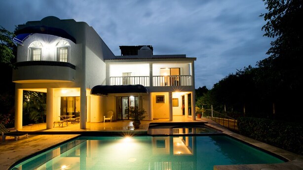 A two-story house with a swimming pool, large windows, and outdoor seating. - Villa Torres Cozumel is a Private Luxurious Oceanfront  Home (Cozumel)