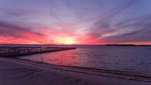 Muelles que se adentran en aguas tranquilas al atardecer, con cielo despejado.