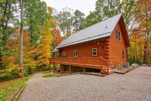 Eine Blockhütte mit Veranda, umgeben von Herbstlaub.