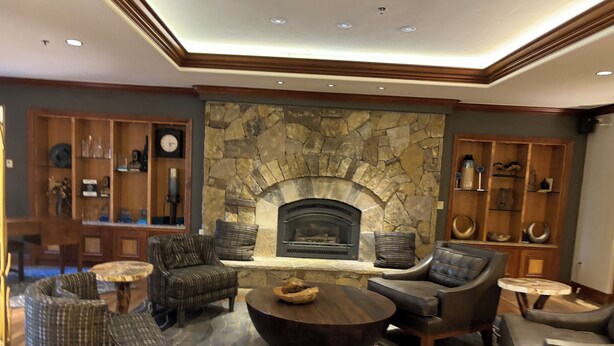 A cozy living room with a stone fireplace, leather sofas, and a coffee table. - Spend the week at Valdoro Mountain Lodge & quaint Breckenridge Village - (Breckenridge)