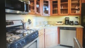 A kitchen with wooden cabinets, a microwave, a stove, and a dishwasher. - Spend the week at Valdoro Mountain Lodge & quaint Breckenridge Village - (Breckenridge)