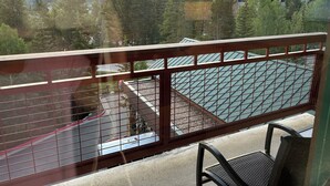 A balcony with a metal railing overlooking a tennis court, surrounded by trees and buildings. - Spend the week at Valdoro Mountain Lodge & quaint Breckenridge Village - (Breckenridge)