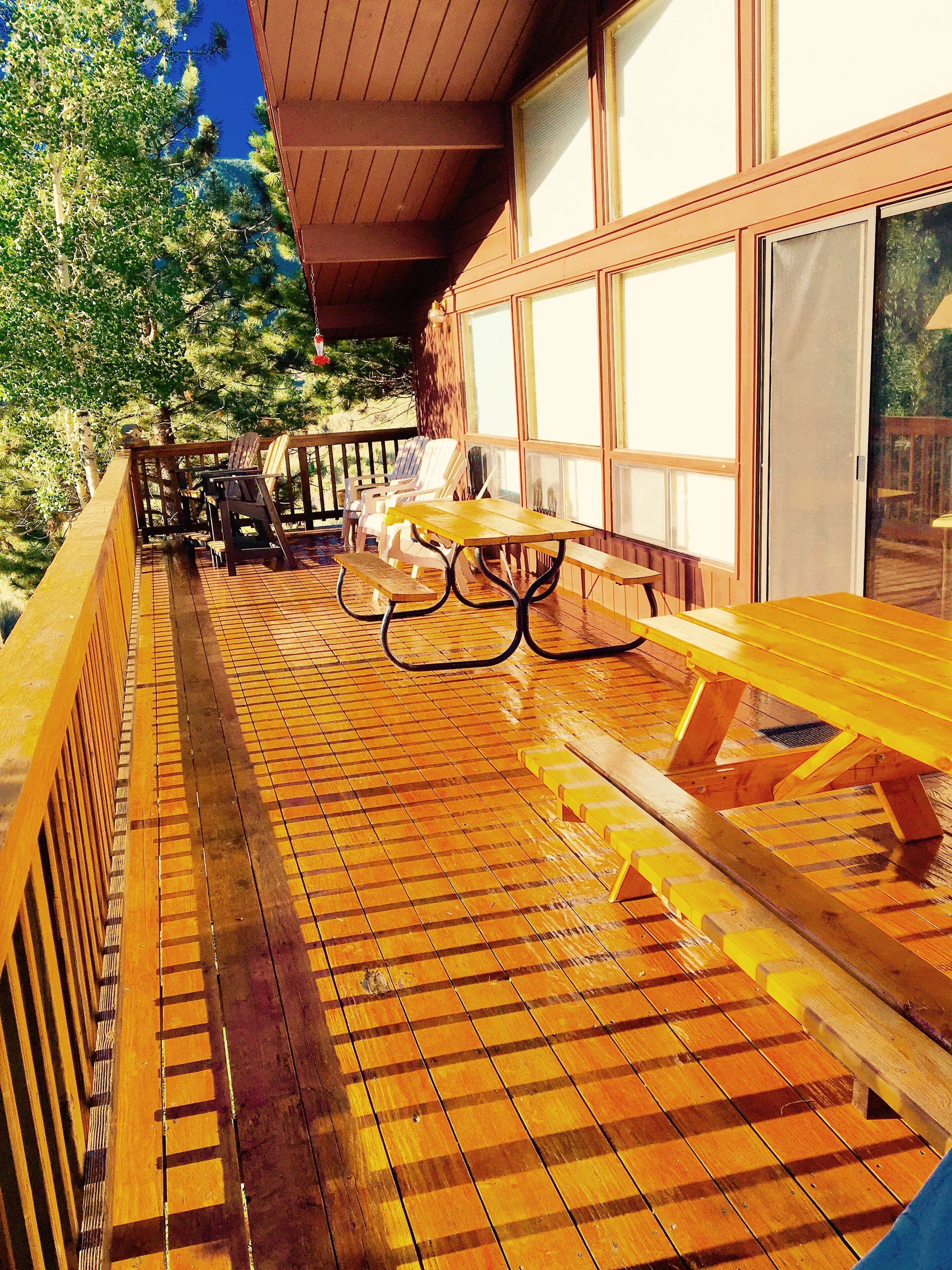 View of deck with 2 picnic tables, lawn chairs & grill this end (not captured).