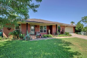 Stunning home with a charming front porch, garage door, and beautifully manicured lawn.