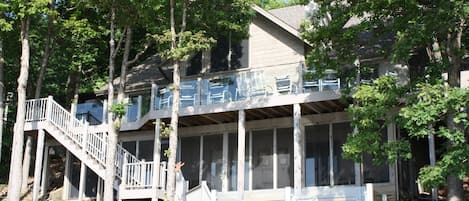 A two-story house with a balcony, a staircase, and a deck.