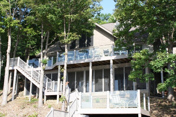 A two-story house with a balcony, a staircase, and a deck.