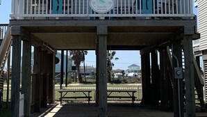 A two-story building with a balcony, a sign reading "TipSea Turtle", and a number "115" on the post. - The Beach and Surf is Just Steps Away! (Surfside Beach)