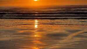 A beach with a sunset over the ocean. - The Beach and Surf is Just Steps Away! (Surfside Beach)