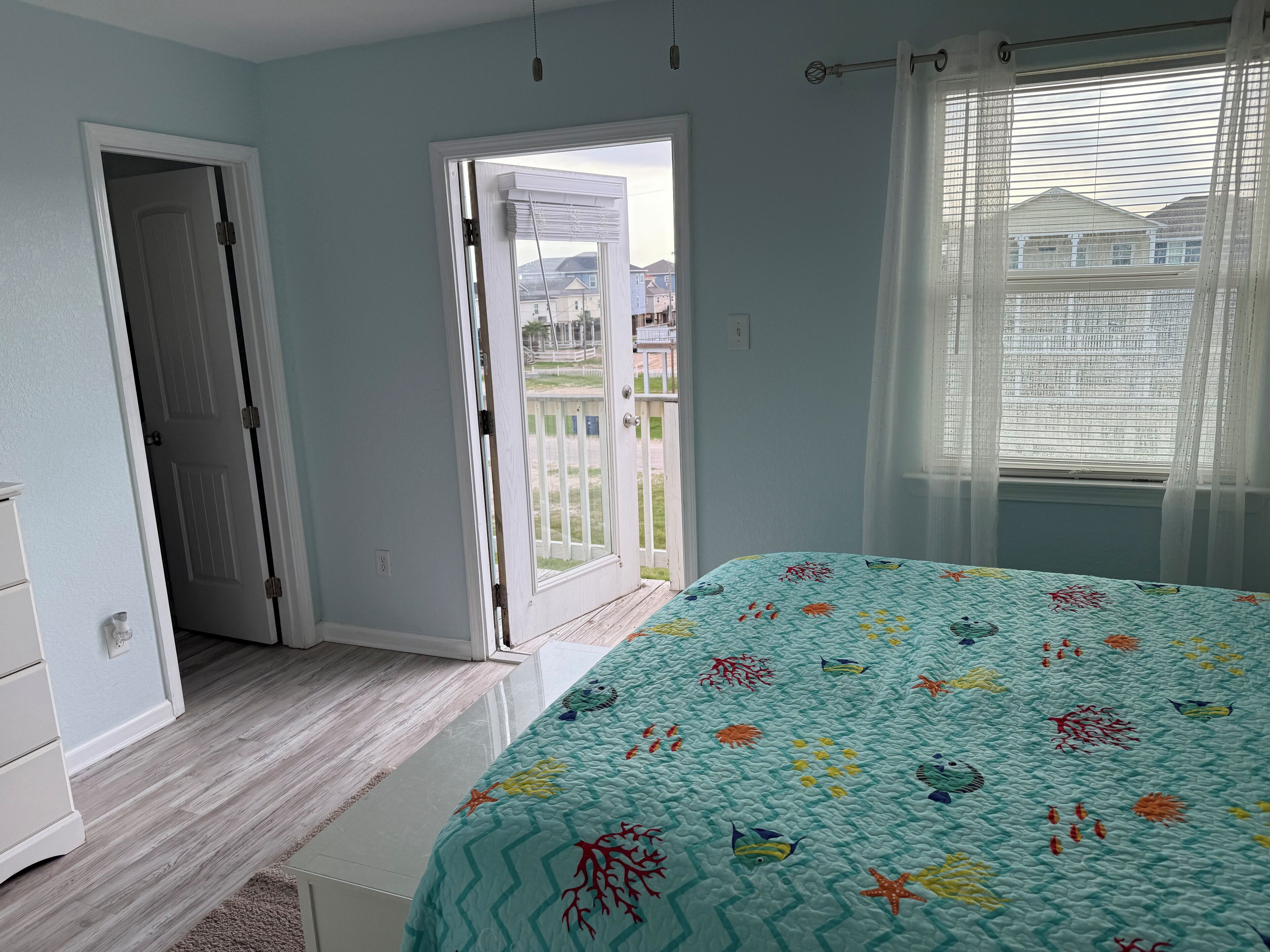 Une chambre à coucher avec un lit, une porte et une vue sur l’extérieur.
