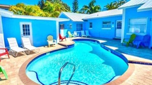 A pool area with lounge chairs and a pool. - VILLA 4, Siesta Key, Walk to Beach. Pool. Daily Rentals (Sarasota)