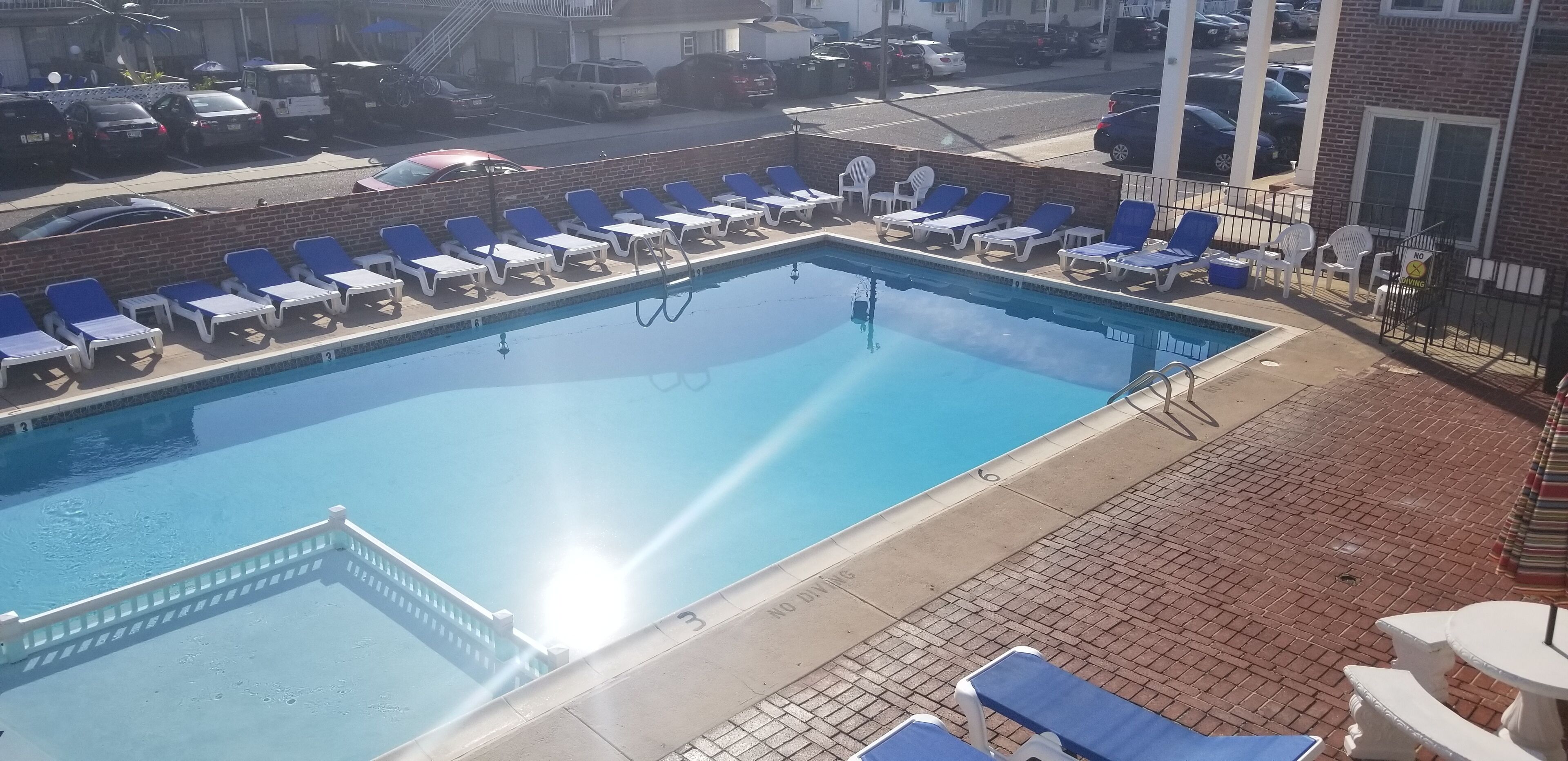Piscina com espreguiçadeiras e trampolim.