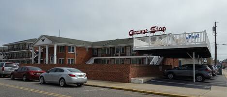 A two-story building with a balcony and a sign that reads 'Carriage Stop.'