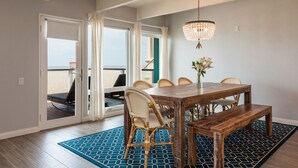 Ein Essbereich mit einem Holztisch, Stühlen und einer Bank. Über dem Tisch hängt eine Chandelier.