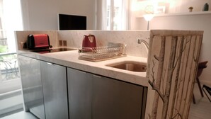 Eine moderne Küche mit einem Edelstahlkühlschrank, einem roten Toaster und einer Kaffeemaschine auf der Arbeitsplatte.